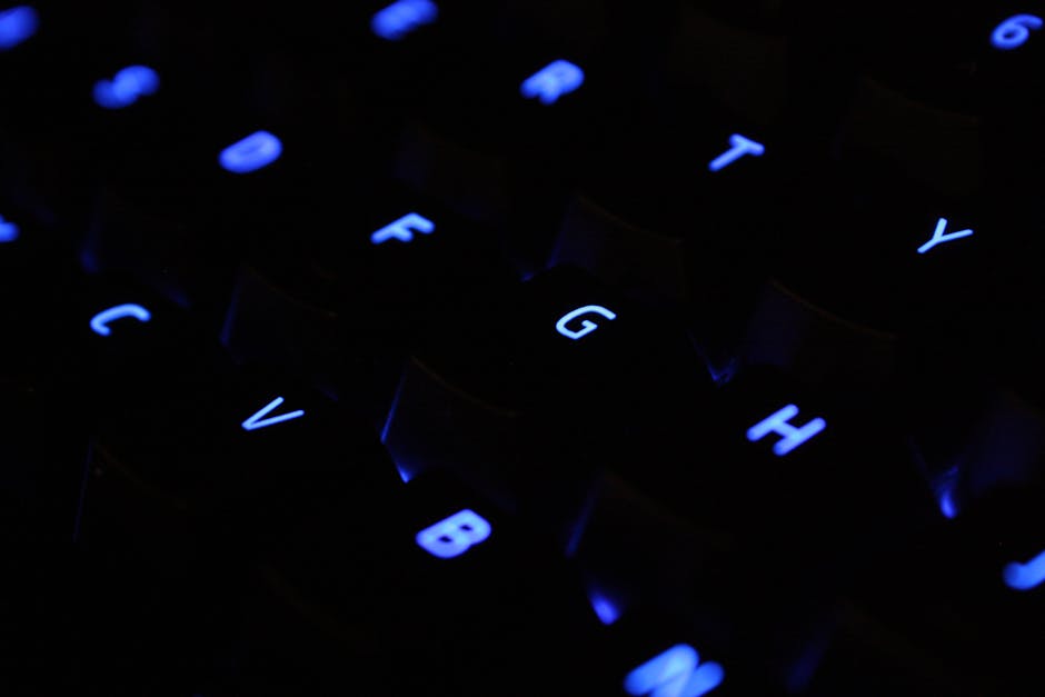 A detailed shot of blue backlit keyboard keys in a dark setting.