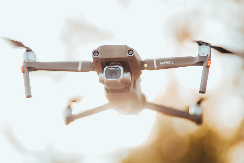 A detailed close-up of the Mavic 2 drone in flight against a blurred outdoor background.